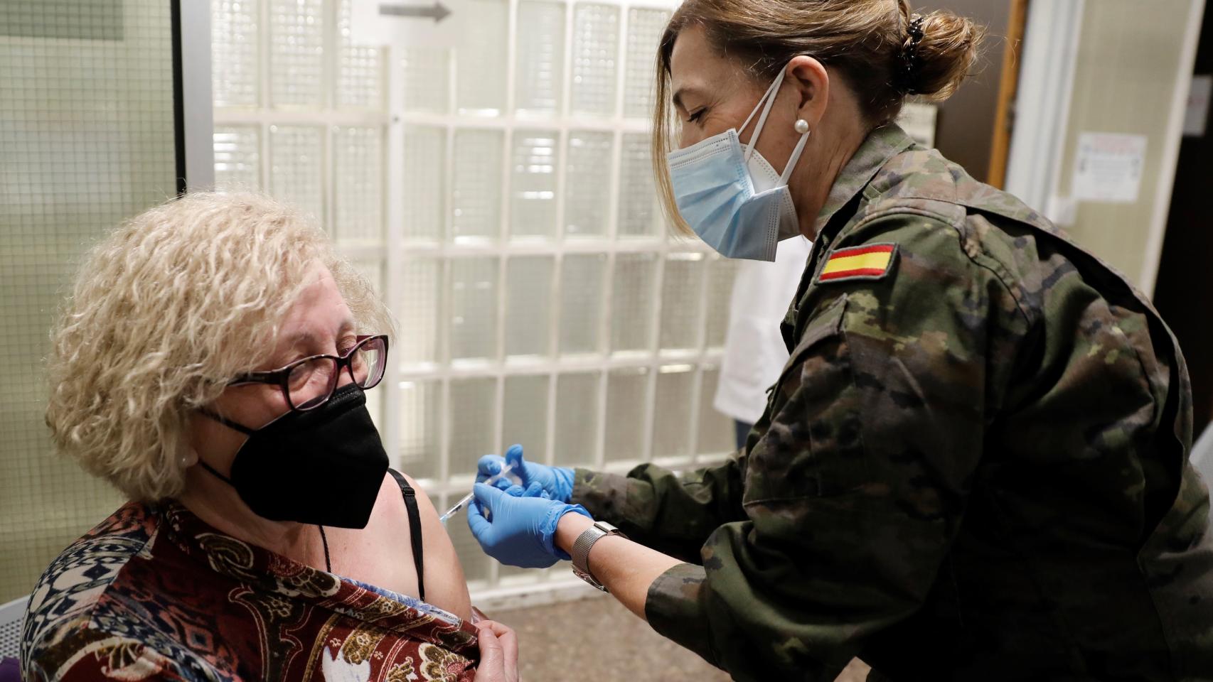 Una militar vacuna a una ciudadana.