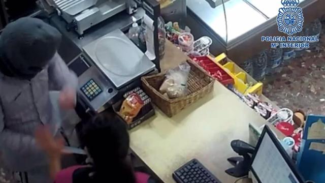 Imagen del presunto atracador ahora detenido cuando amenazaba a la dependienta de la tienda de Estepona.
