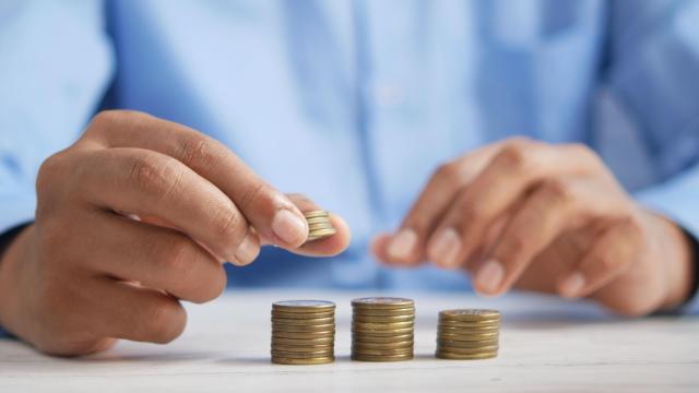 Un hombre apila monedas.