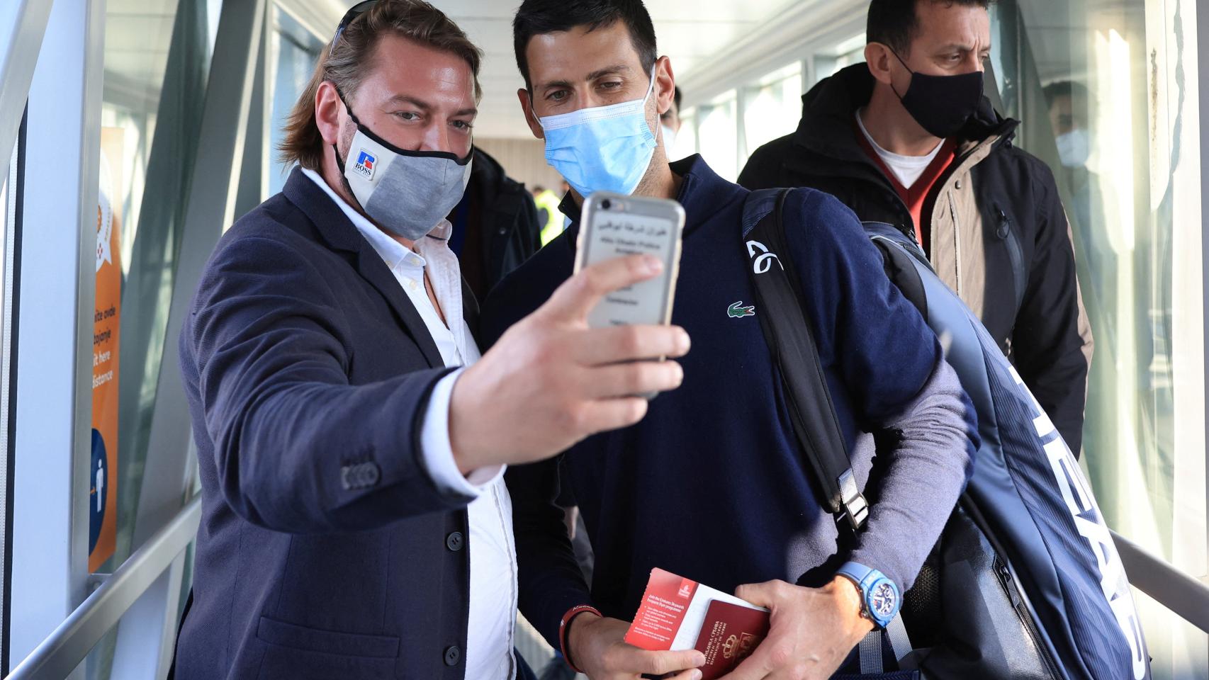 Un hombre se hace un selfie con Novak Djokovic.