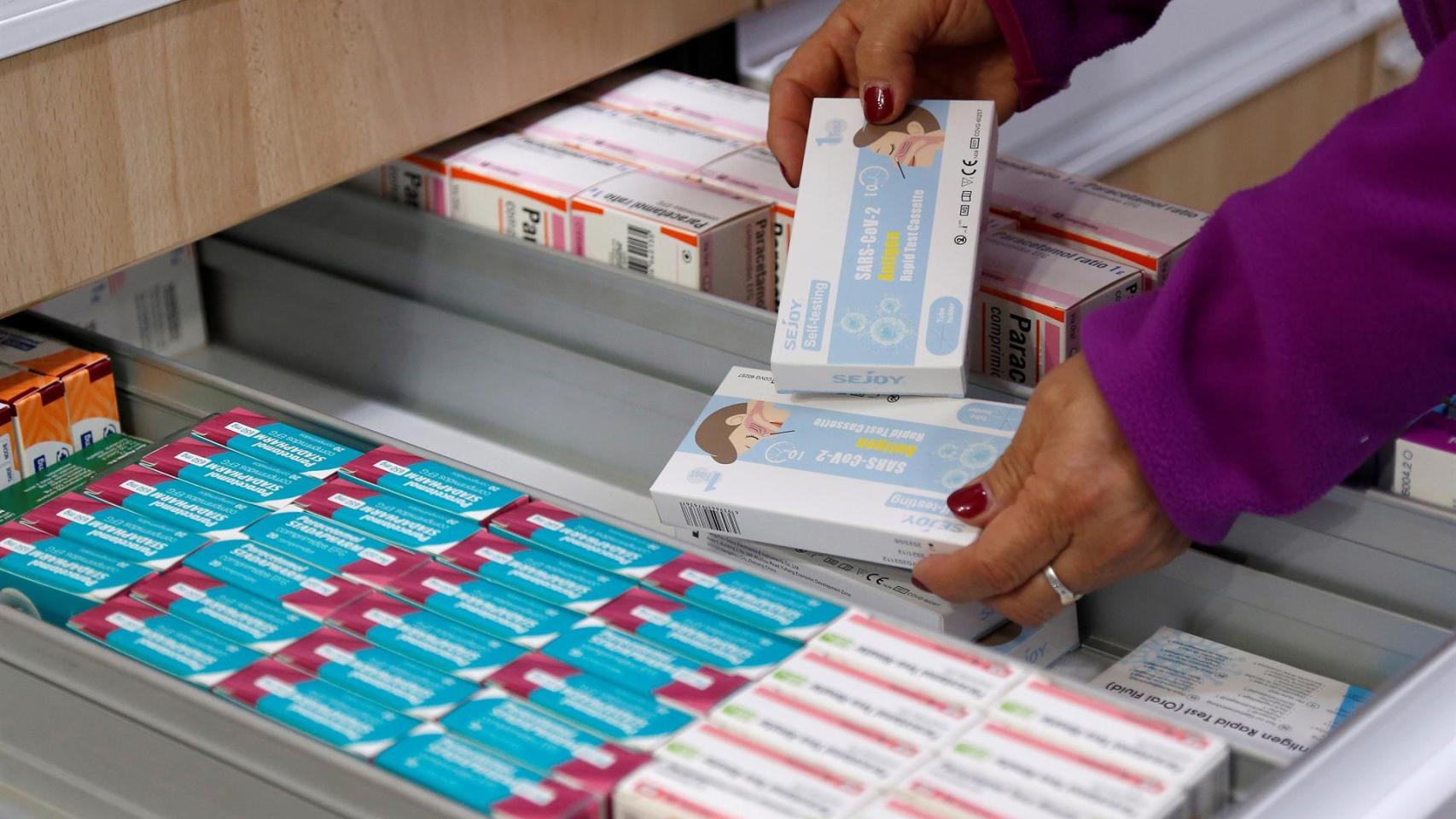 Una farmaceutica muestra unos autotest.