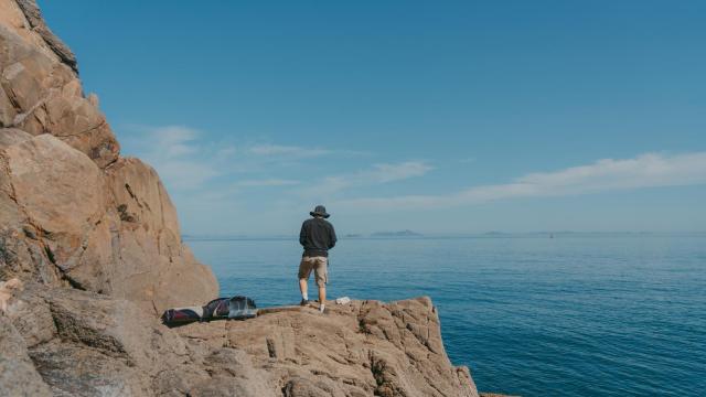 Un hombre pescando en un acantilado.