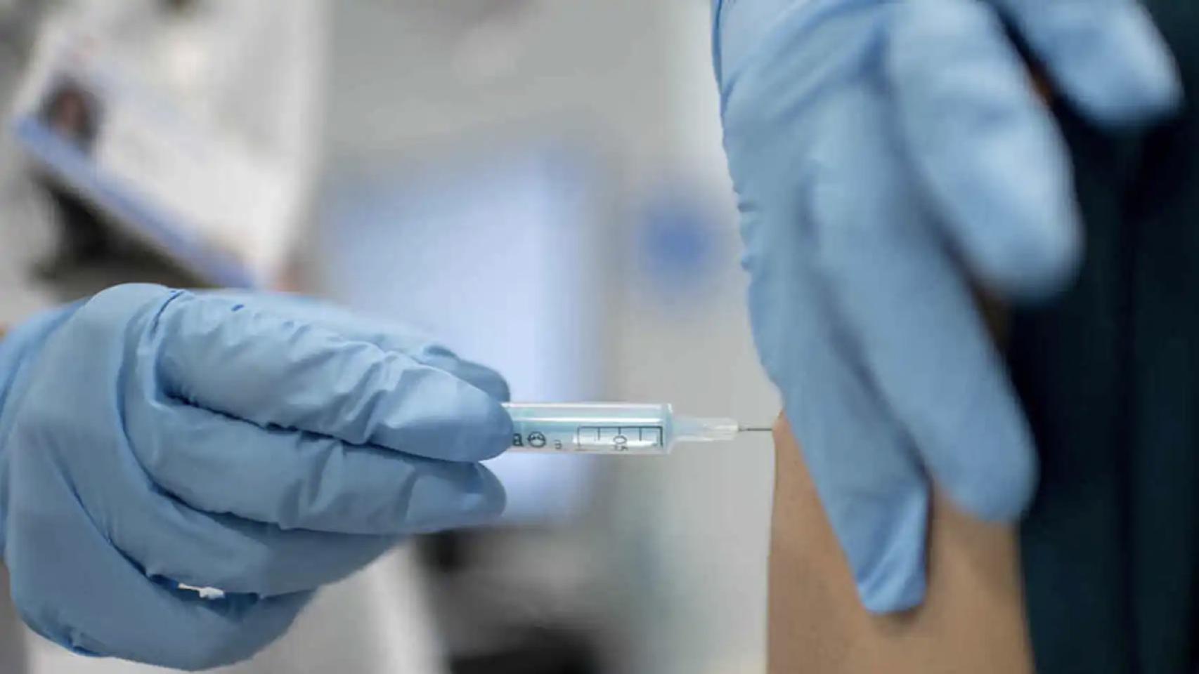 Un sanitario administra una vacuna a un paciente.