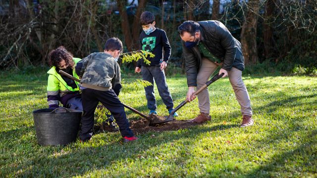 Niños plantando un árbol junto al alcalde de Gondomar.