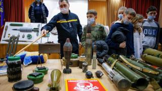 A sapper from the Ukrainian State Emergency Service shows mock bombs to students during bomb threat training at a local school in kyiv.