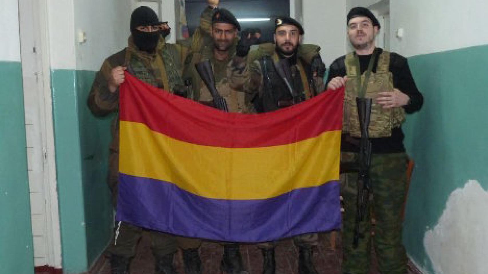 Los combatientes españoles (a cara descubierta y de izquierda a derecha) Sergio Becerra, Ángel Arribas y Héctor Arroyo posan con una bandera republicana en el Este de Ucrania en 2014.
