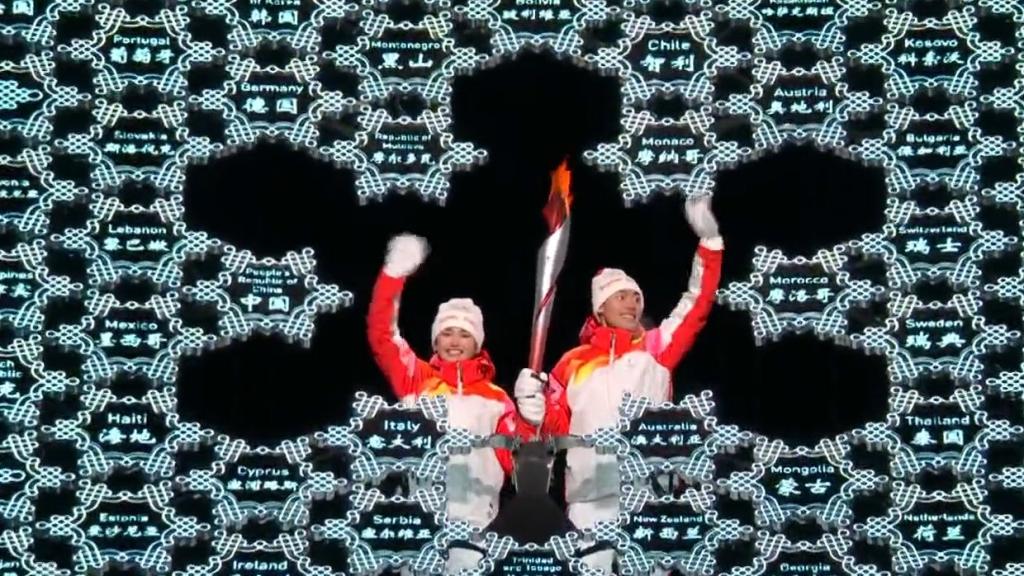 A la izquierda de la imagen, Dinigeer Yilamujiang, de origen uigur, encendiendo el pebetero olímpico.