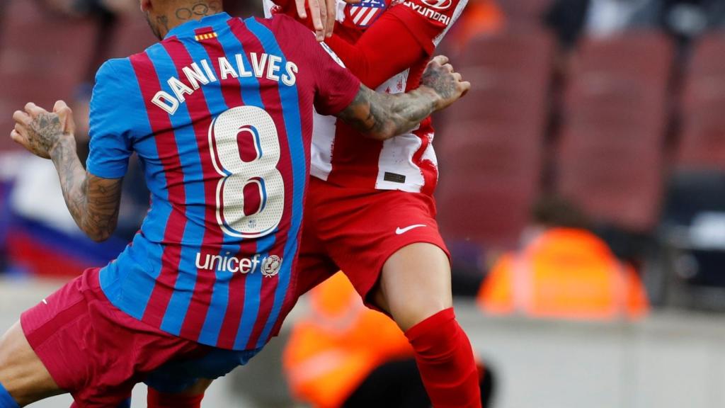 Dani Alves y Joao Félix pugnan por un balón.