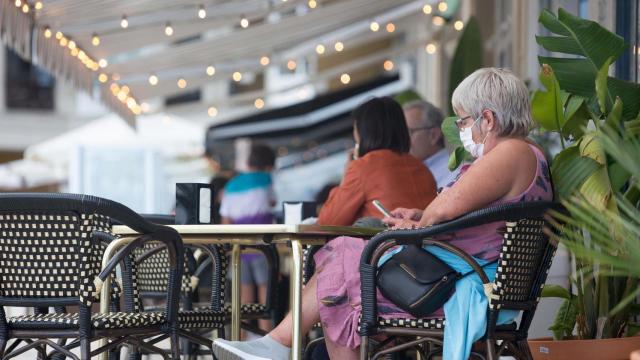 Unos clientes tomando algo en una terraza, en una imagen de archivo