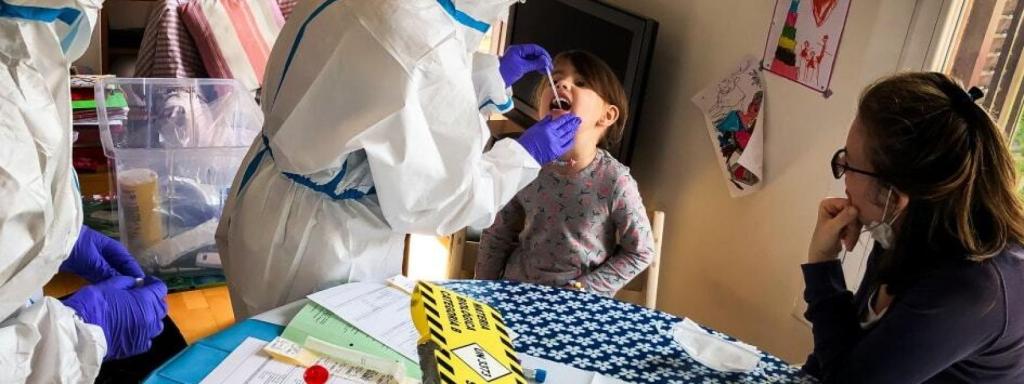 Una sanitaria hace un test de saliva a un menor.