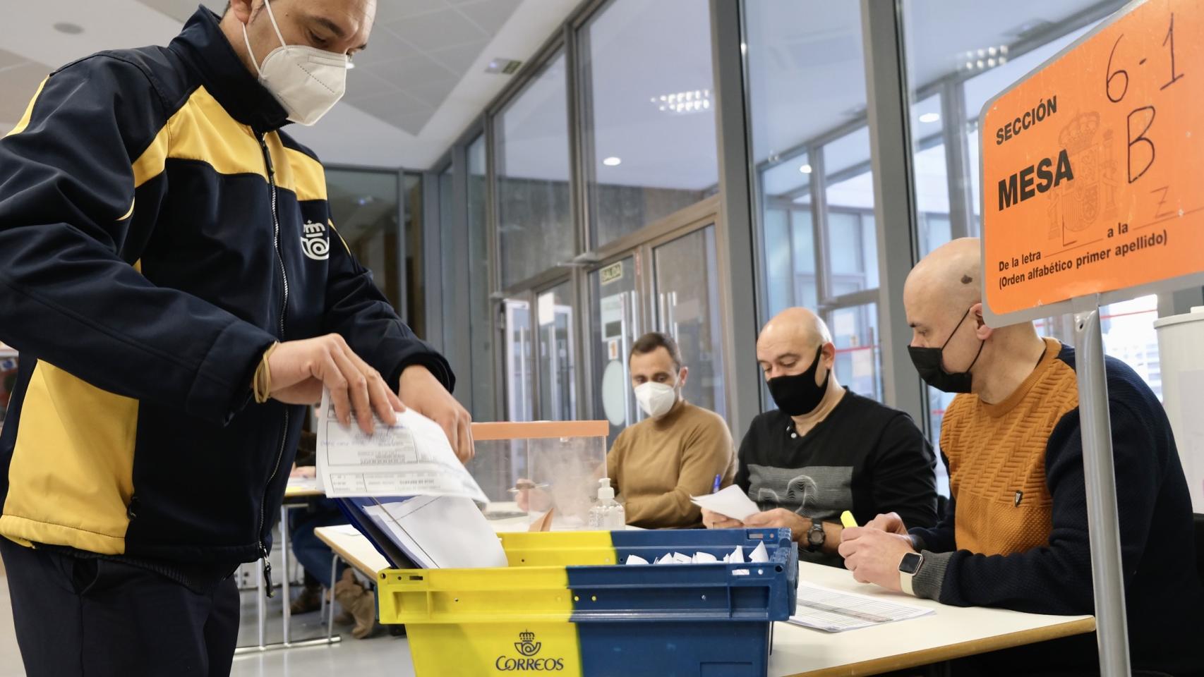 Un empleado entrega el voto por correo en una mesa electoral en las elecciones de Castilla y León
