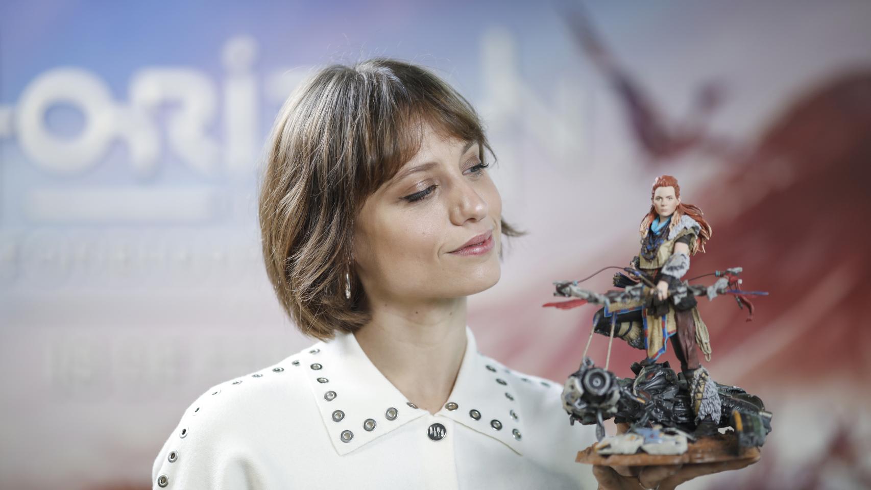 Michelle Jenner junto a una figura de Aloy, a la que pone voz en el videojuego Horizon Forbidden West.