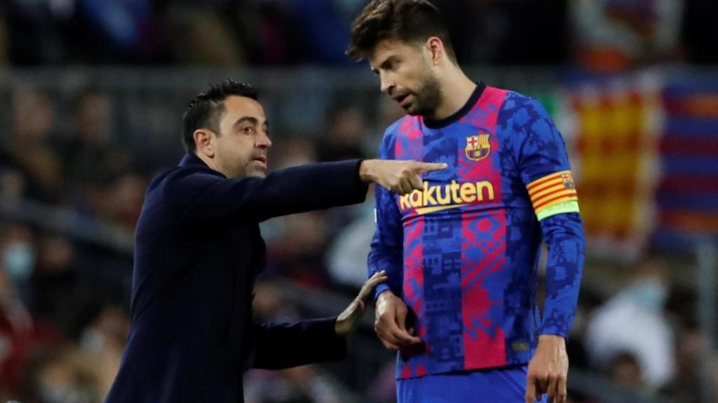 Xavi Hernández hablando con Piqué en la banda