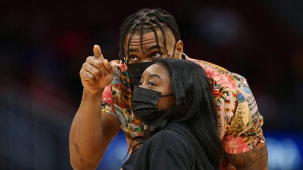 Jonathan Owens y Simone Biles, en un partido de los Houston Rockets y Los Ángeles Lakers.