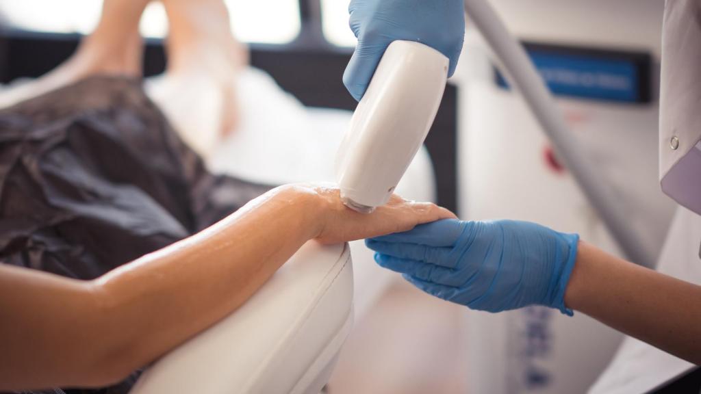 Una mujer se depila el brazo con láser.