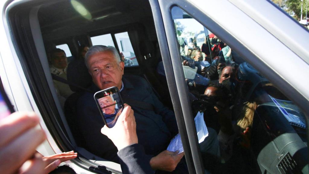 López Obrador rodeado por manifestantes que piden justicia para los cinco periodistas mexicanos asesinados en 2022.