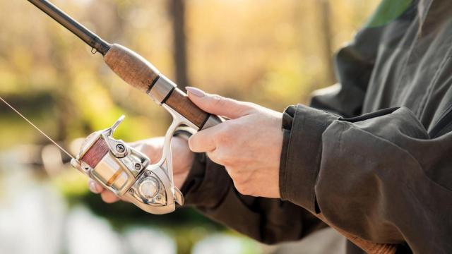 Las manos de un pescador sosteniendo su caña.