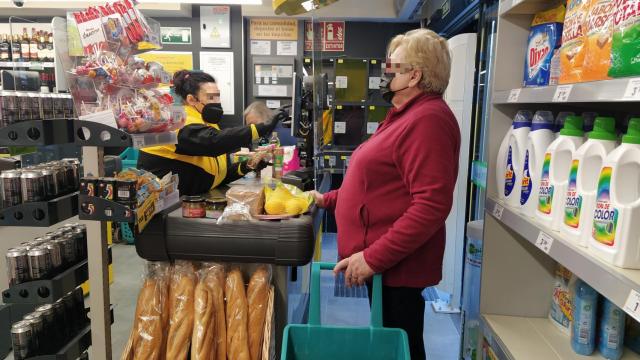 Una empleada del Ahorramás Basic atendiendo a una clienta.