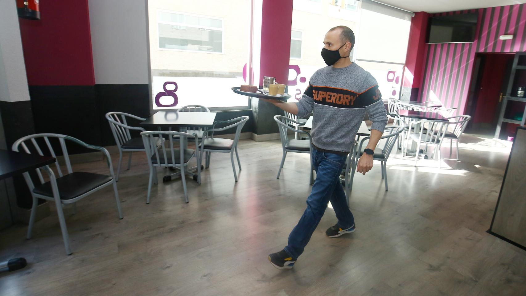 Un camarero atiende a sus clientes en una cafetería