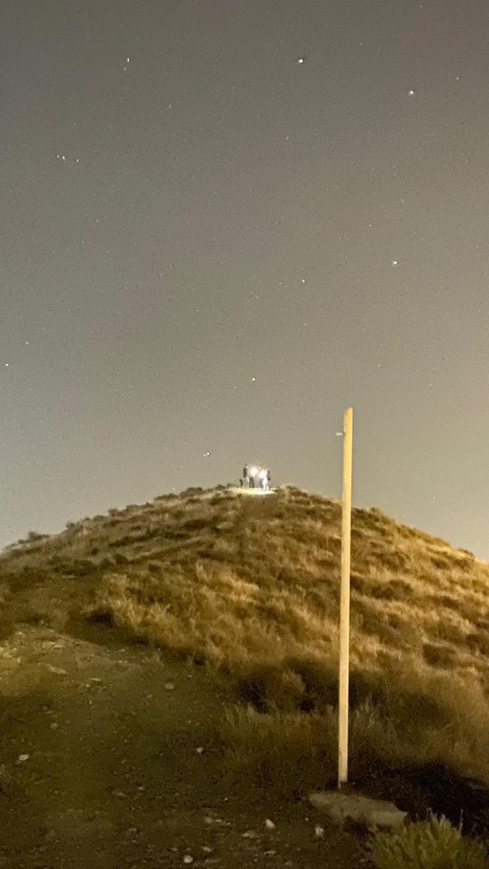 Un grupo de agentes, con linternas, inspeccionando el cerro donde fue localizado el cuerpo del bebé.
