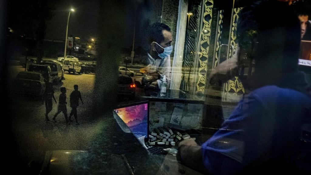Tres migrantes y refugiados en las calles de Trípoli en agosto de 2021.