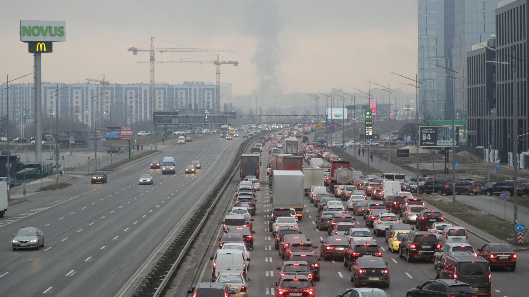 Los habitantes de Kiev intentan huir de la ciudad, con las columnas de humo al fondo.