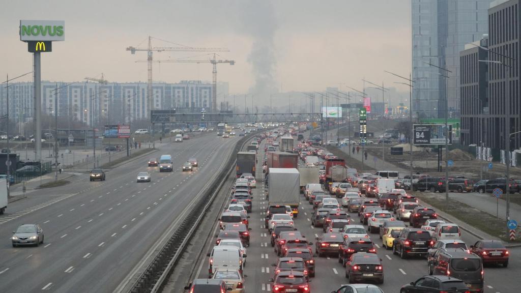 Los habitantes de Kiev intentan huir de la ciudad, con las columnas de humo al fondo.