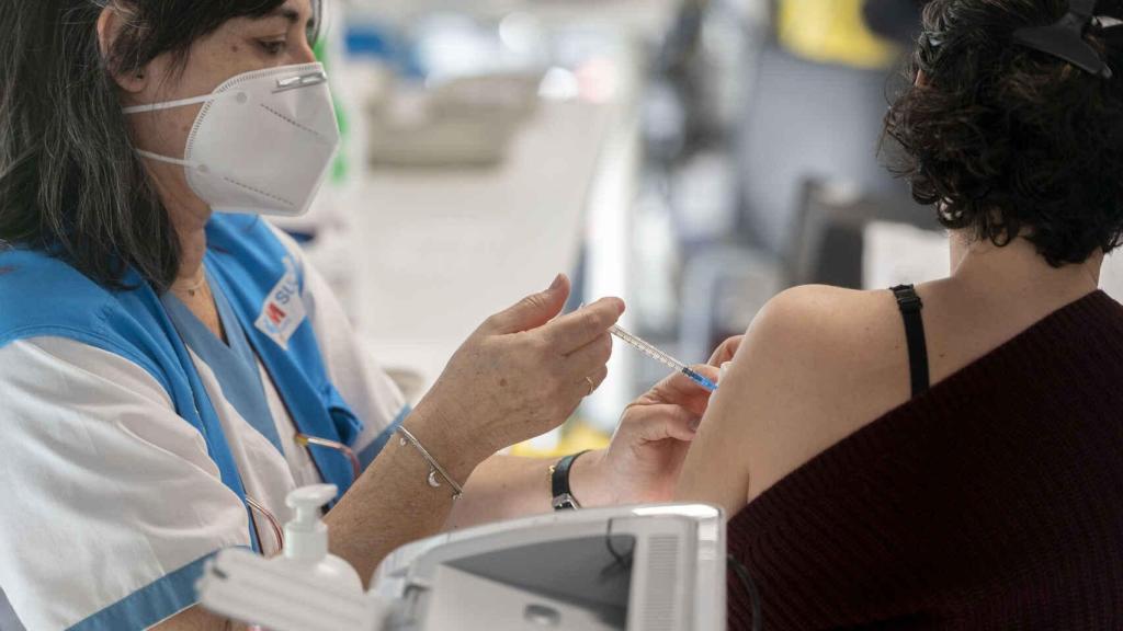 Una sanitaria poniendo una vacuna.