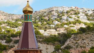 La iglesia ortodoxa rusa de Altea frente al fondo de la lujosa urbanización de la que se dijo que visitó Putin.