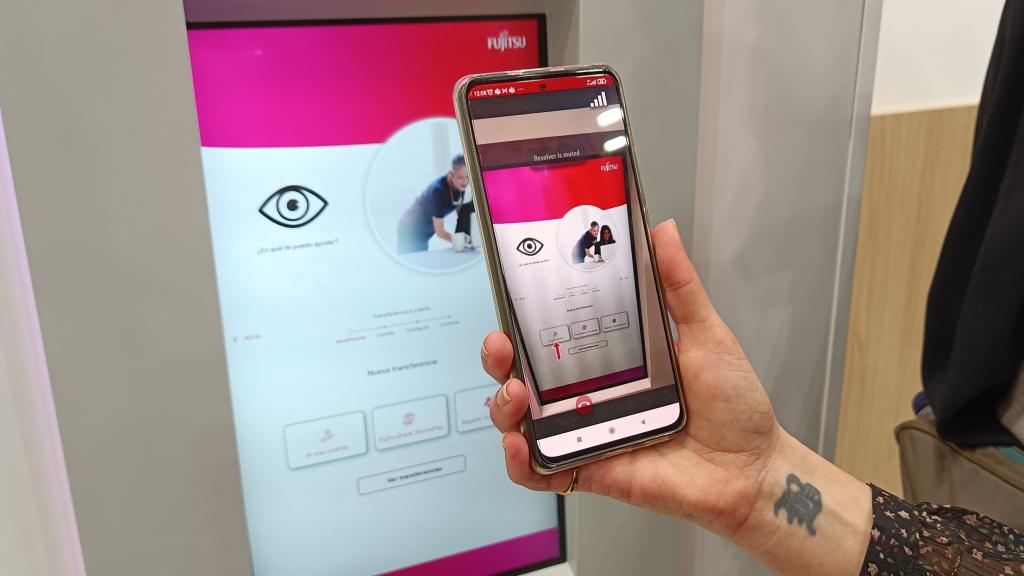 El técnico marca el botón en el móvil ante el cajero de Fujitsu