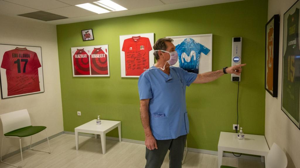 Mikel Sanchez señala algunas de las camisetas de deportistas famosos que adornan su consulta.