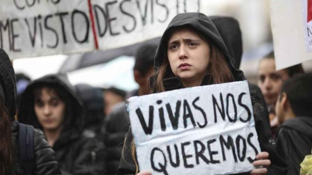 Una mujer sostiene una pancarta durante una manifestación