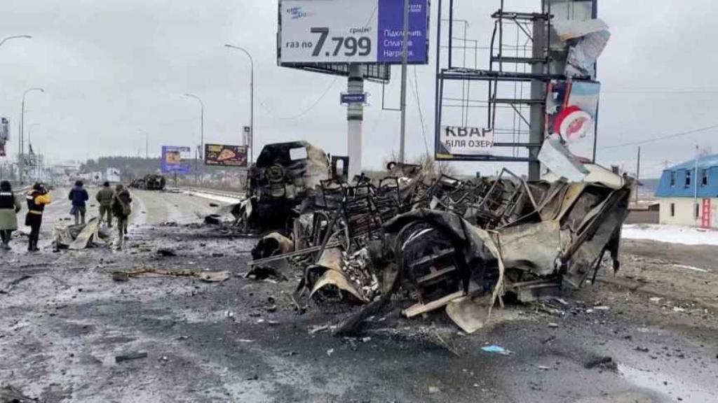 La gente camina junto a un vehículo destrozado por los bombardeos de Rusia sobre la ciudad de Bucha. Foto: Reuters