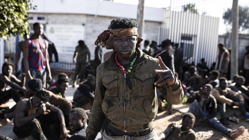 Un migrante hace el signo de la victoria, tras conseguir saltar la valla de Melilla.