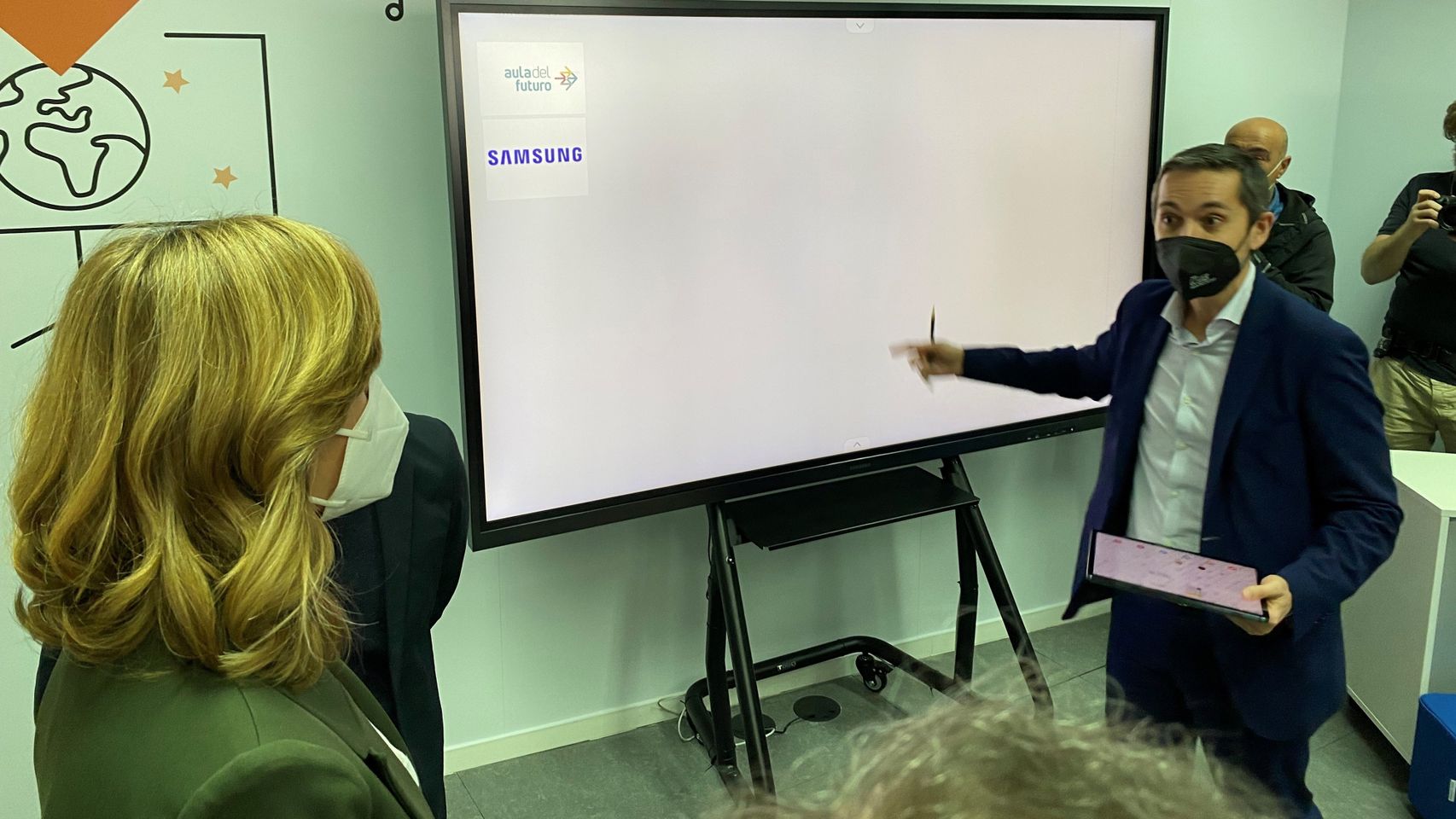 La ministra atiende frente a la pizarra digital de Samsung en el Aula de Futuro de Valencia.