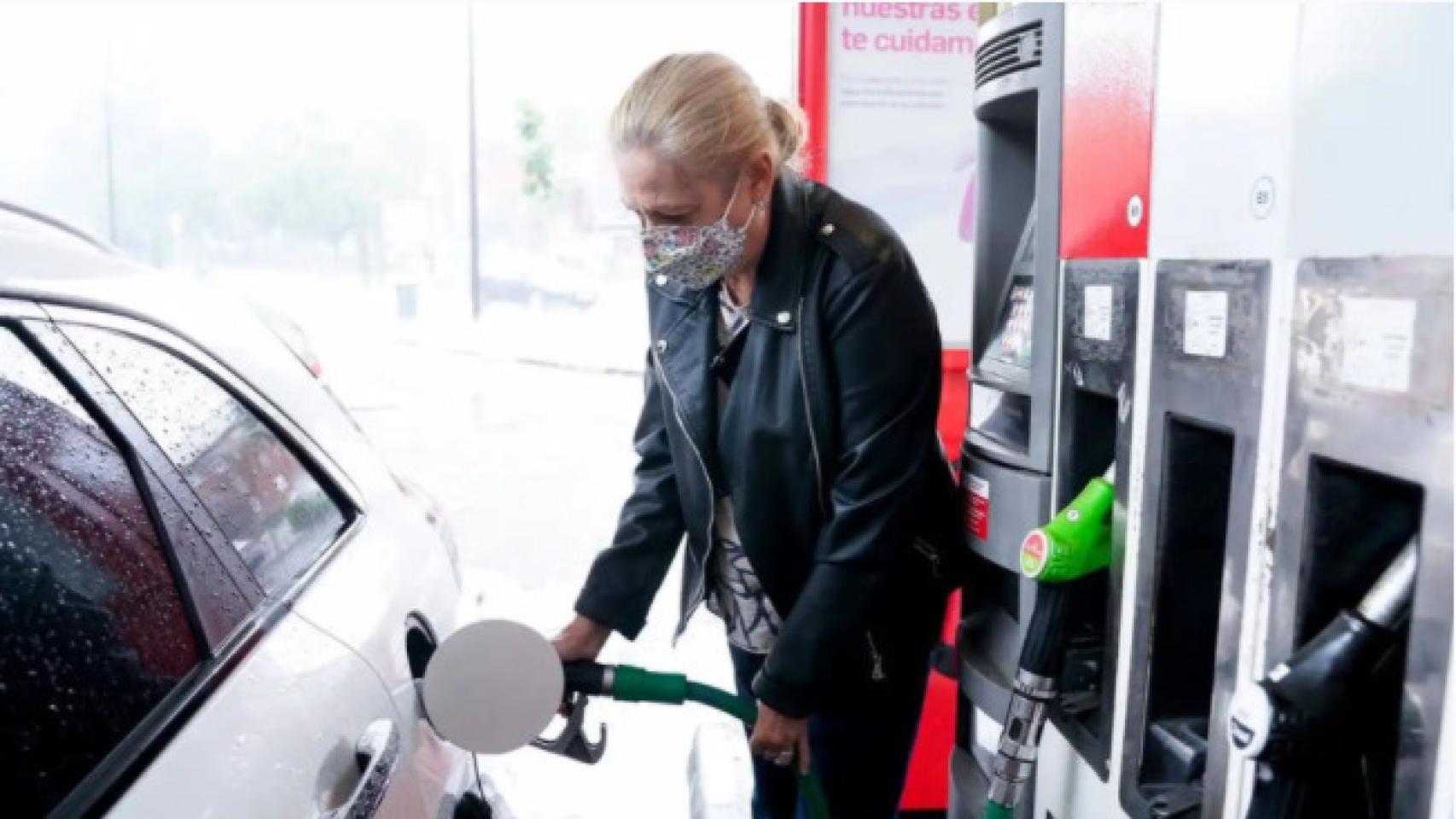 Una mujer reposta combustible en una gasolinera