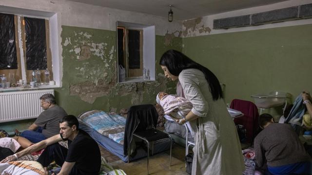 Una madre con su hijo en brazos en el sótano del hospital de Kiev que ahora funciona como refugio antiaéreo.