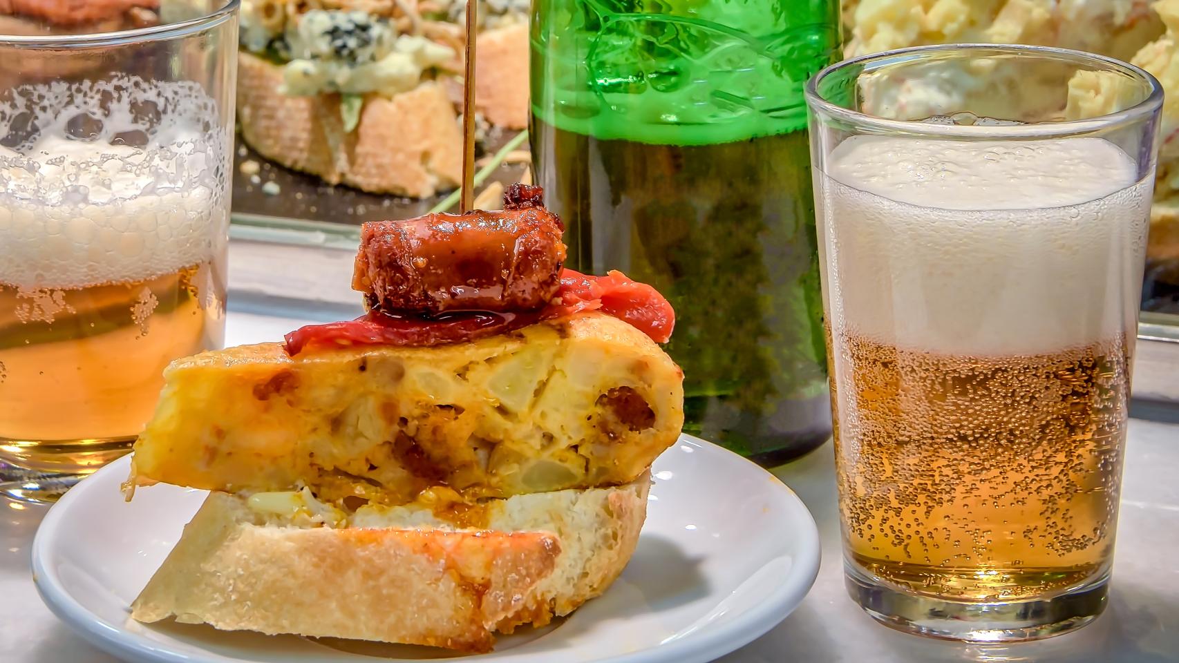 Un pincho de tortilla y chorizo con una caña.