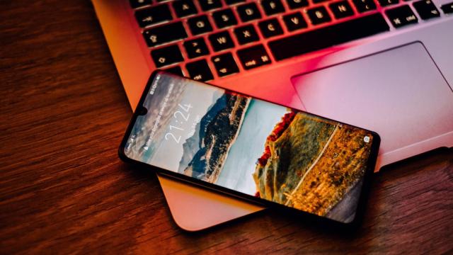 Un smartphone apoyado sobre un ordenador portátil