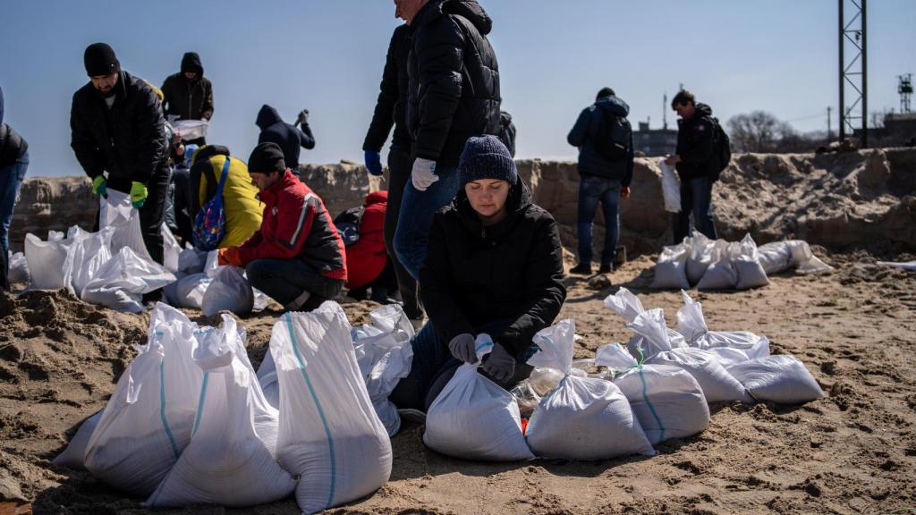 Hasta hace unos días, los sacos se rellenaban con cuatro paladas, a veces más. Sin embargo, los voluntarios se dieron cuenta que la fatiga al cargar los camiones era menor aumentando el número total, pero reduciendo el peso.