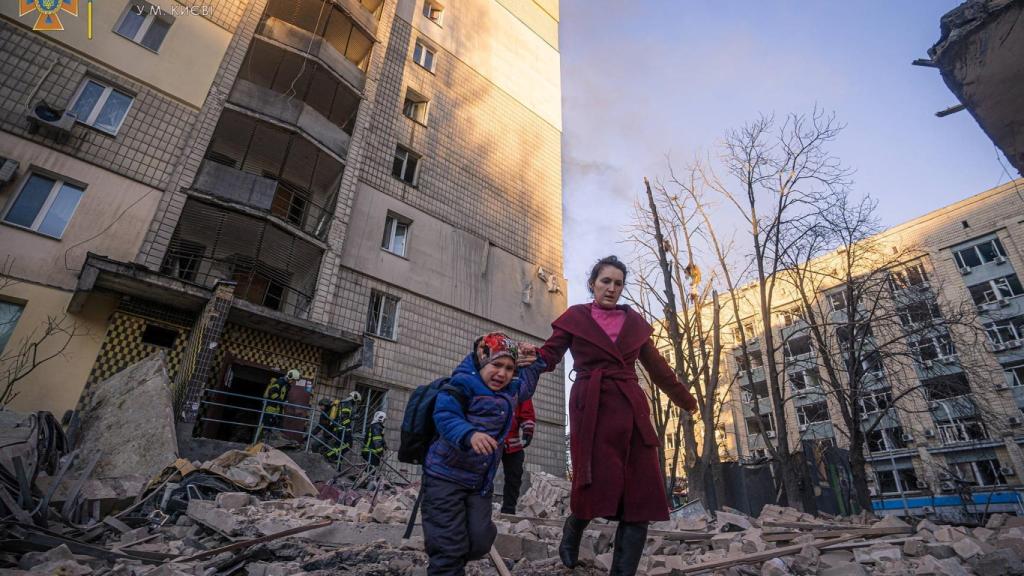 Una mujer y un niño en una zona residencial de las afueras de Kiev bombardeada por el Ejército ruso.