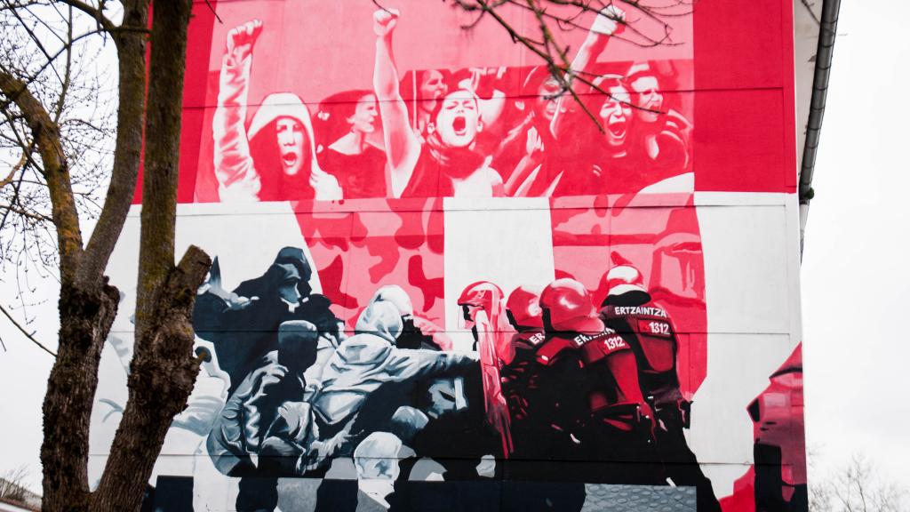 Mural de varios autores que muestra a la Ertzaintza con los números '1312', representación de 'ACAB' (acrónimo que significa todos los policías son unos bastardos en inglés).