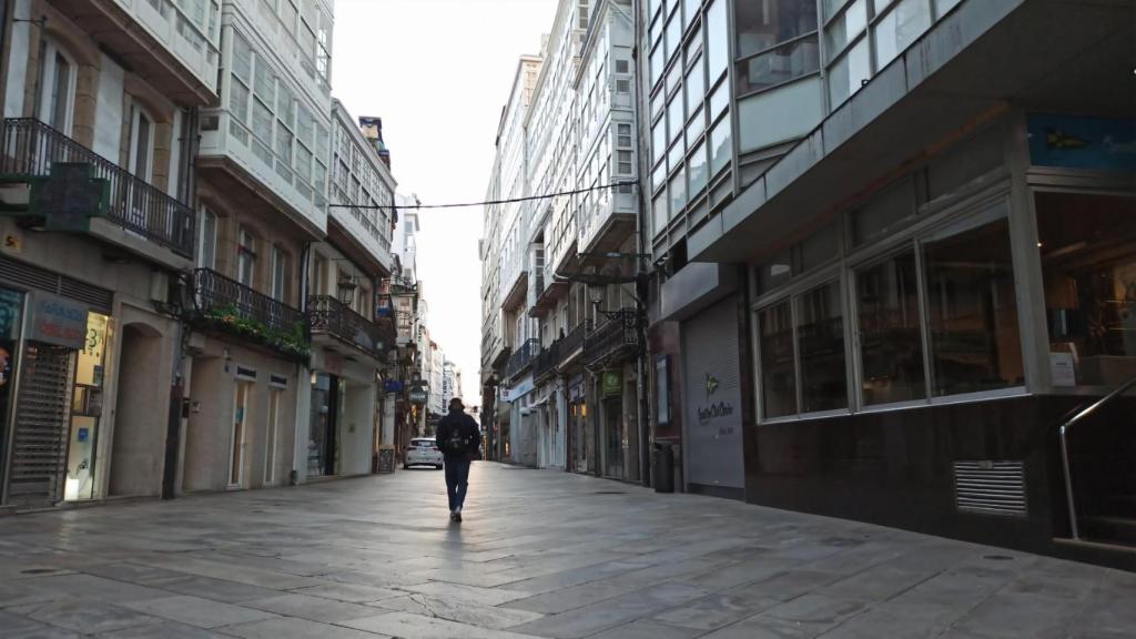 Una persona camina por la Calle Real de A Coruña un día laboral por la mañana.