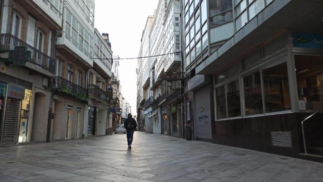 Una persona camina por la Calle Real de A Coruña un día laboral por la mañana.