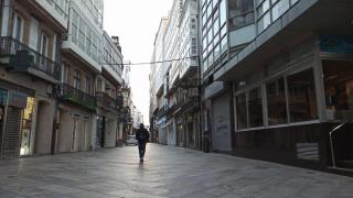 Una persona camina por la Calle Real de A Coruña un día laboral por la mañana.