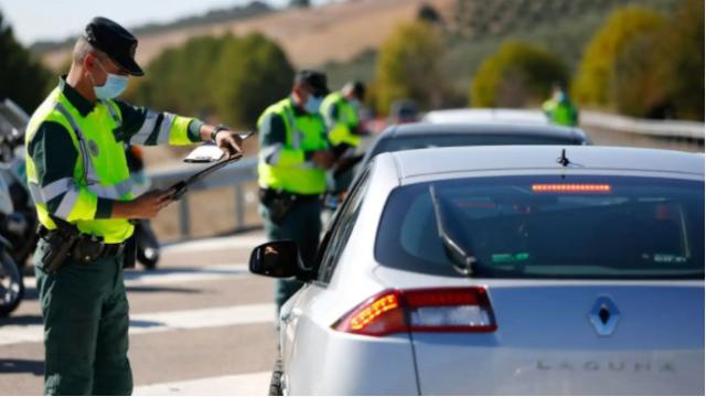 Un agente de la Guardia Civil sancionando a una conductora.