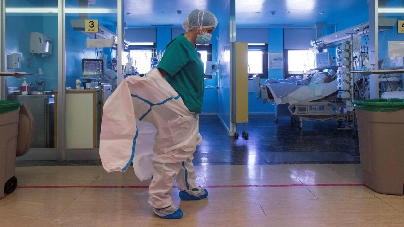 Una sanitaria colocándose un equipo de protección, en imagen de archivo.