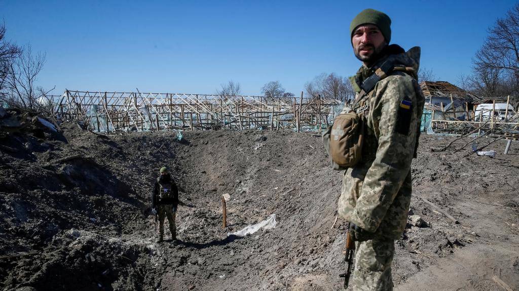 Miembros del servicio ucraniano examinan un cráter provocado por un bombardeo ruso en la región de Kiev.