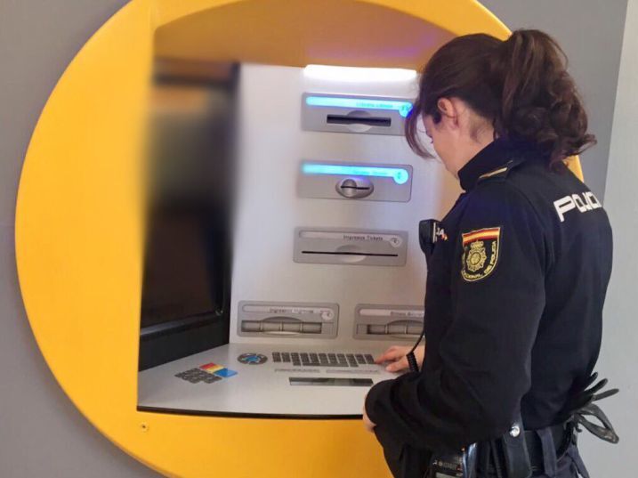 Una Policía Nacional revisa un cajero automático