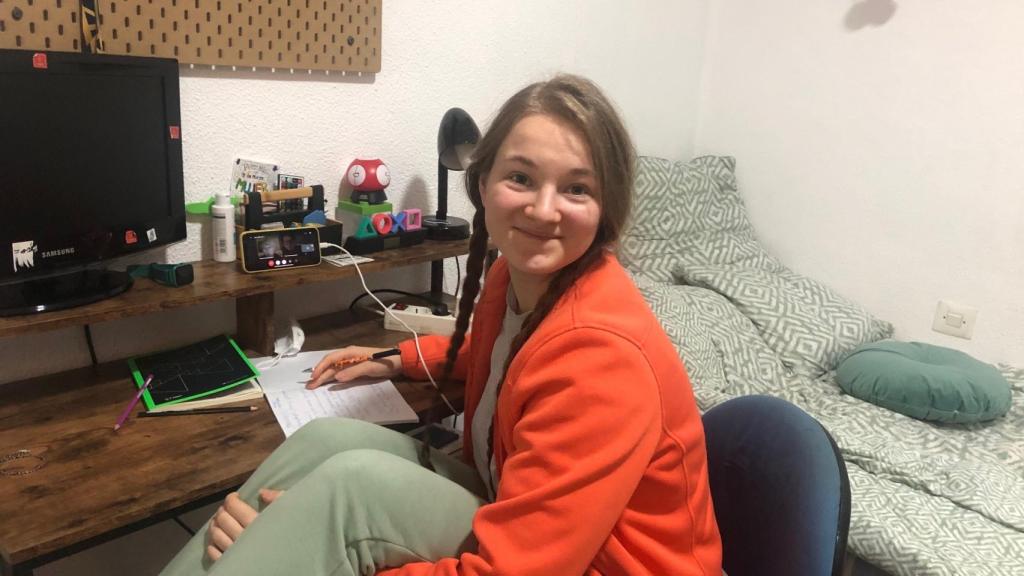 Anastasia mira a la cámara un segundo mientras sigue con su móvil una clase de su facultad.